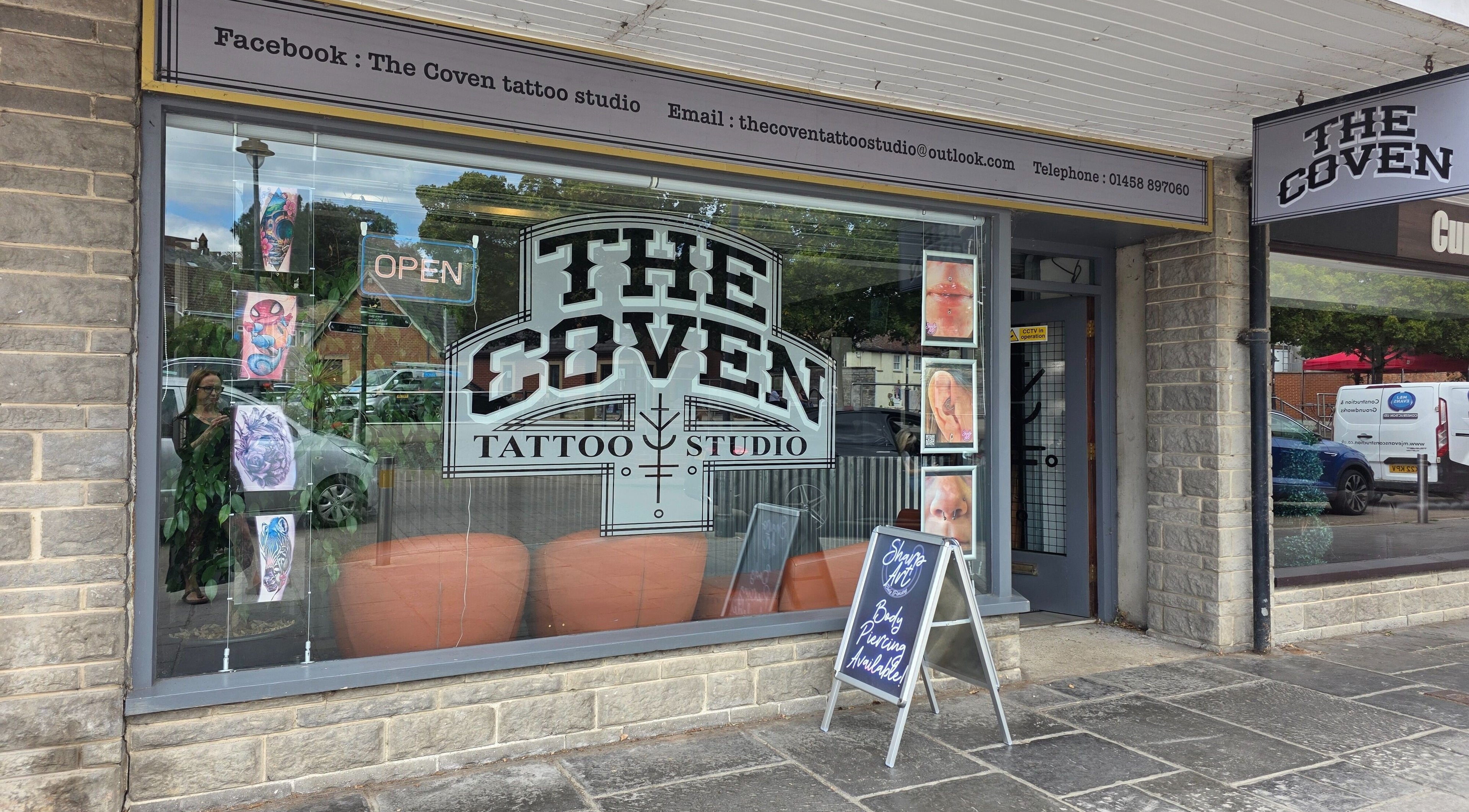 The Coven Tattoo Studio exterior showcasing art and signage for Sharp Art Body Piercing in Langport, England, GB.