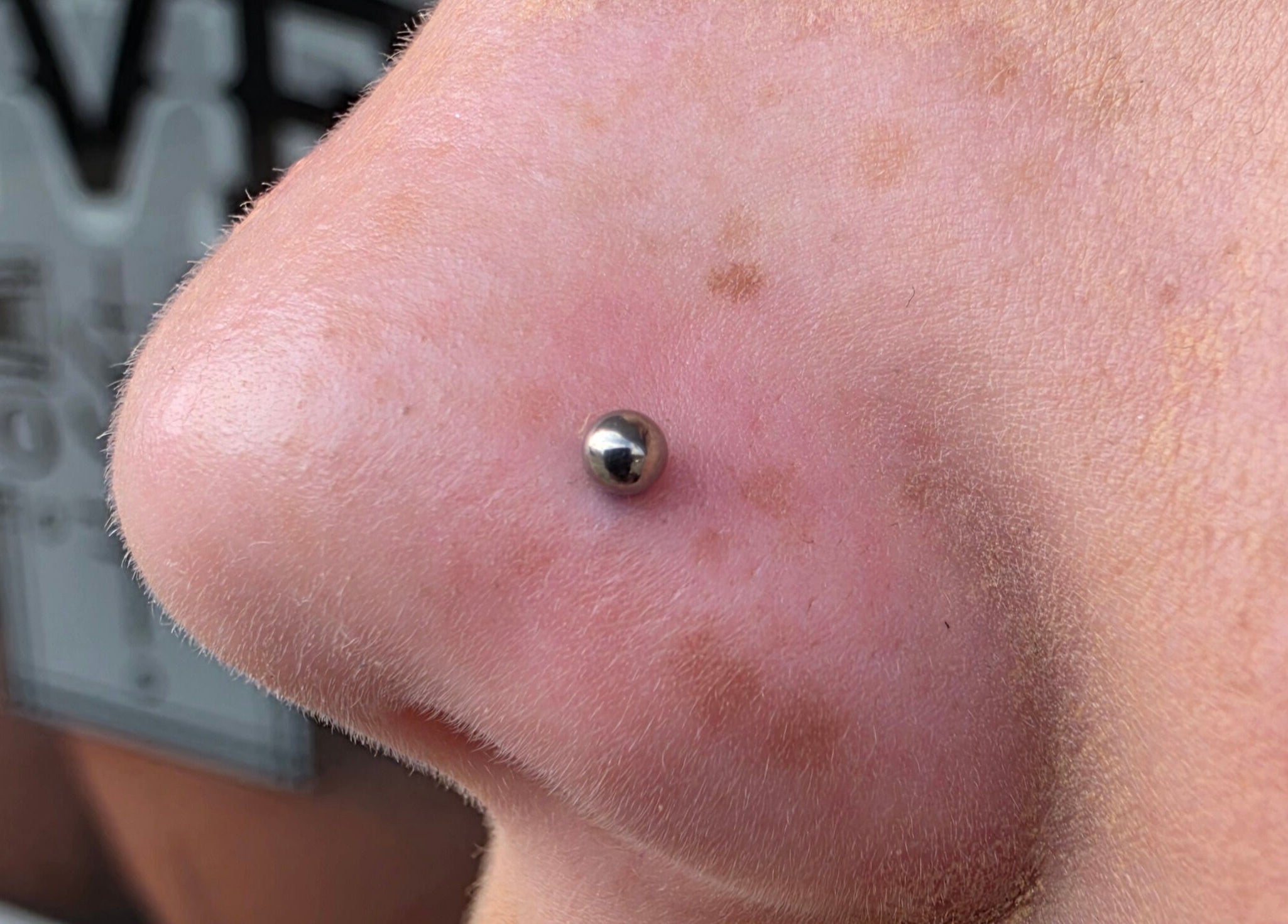 Nose piercing with a silver stud at Sharp Art Body Piercing, Langport, England, GB.