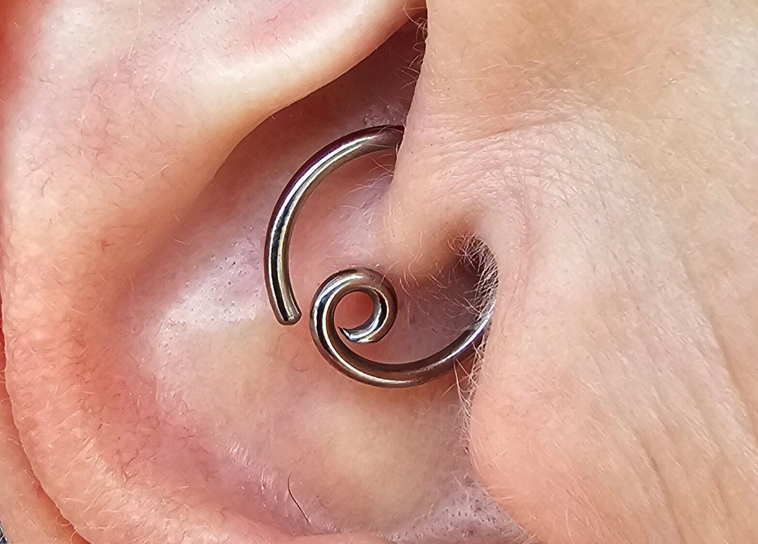 Stylish ear piercing with spiral hoop at Sharp Art Body Piercing, Langport, England, GB.