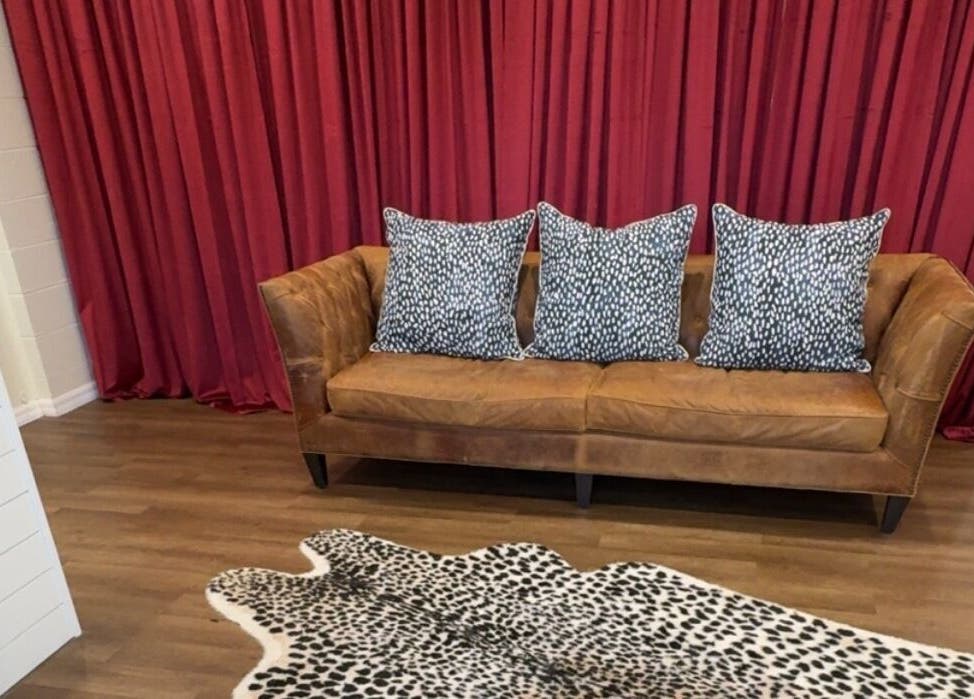 Cozy brown sofa with patterned pillows at Fair City Faces, Philadelphia, Mississippi, US venue.