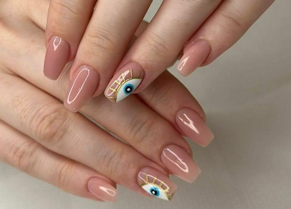 Stylish nail art at Amber Beauty Salon | Meydan, Dubai, Dubai, AE. Features unique eye design on nude polish.