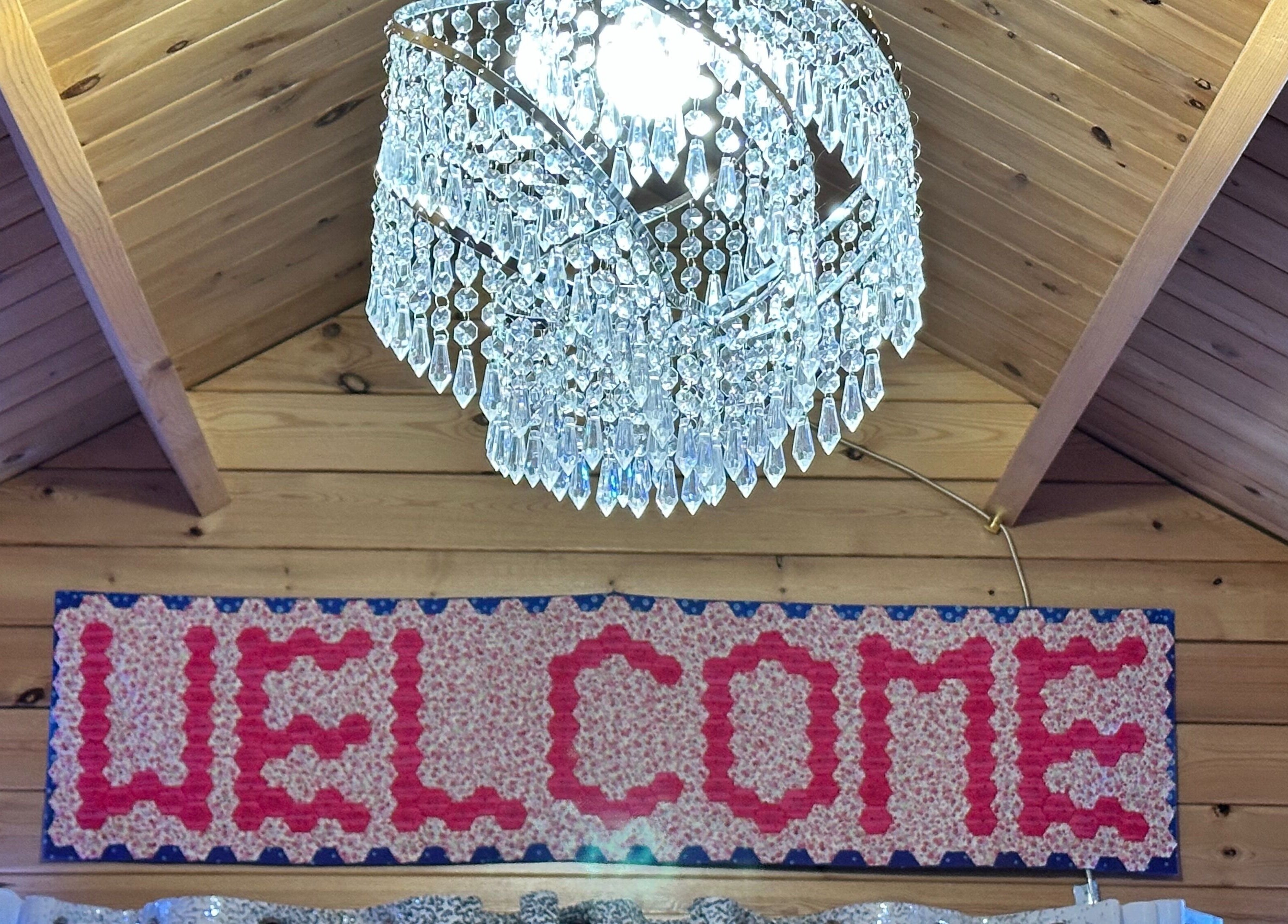 Elegant chandelier and welcome sign at The Dolls House Nail Studio, Renwick, Marlborough, NZ.