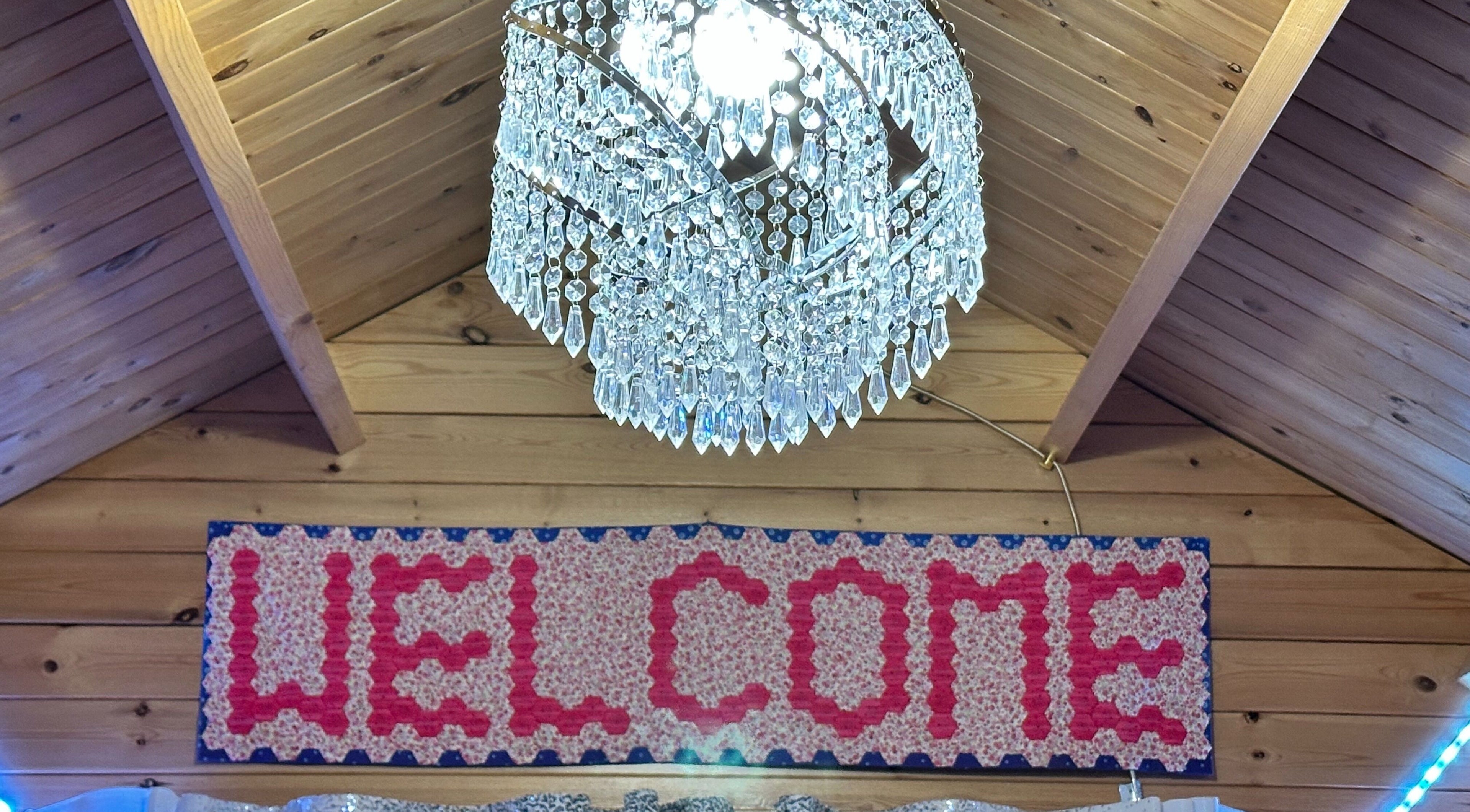 Elegant chandelier and welcome sign at The Dolls House Nail Studio, Renwick, Marlborough, NZ.