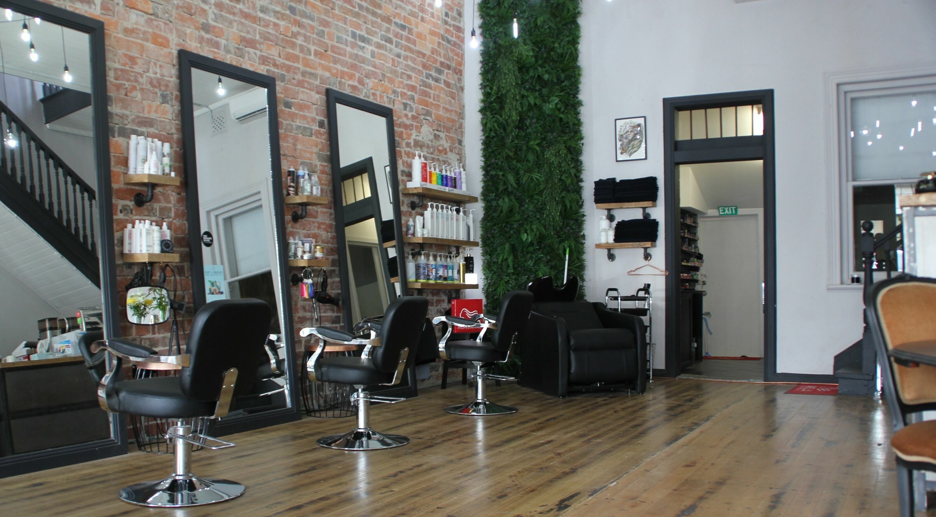 Stylish interior of Alchemy Aesthetics in Ballarat Central, Victoria, showcasing sleek chairs and exposed brick walls.