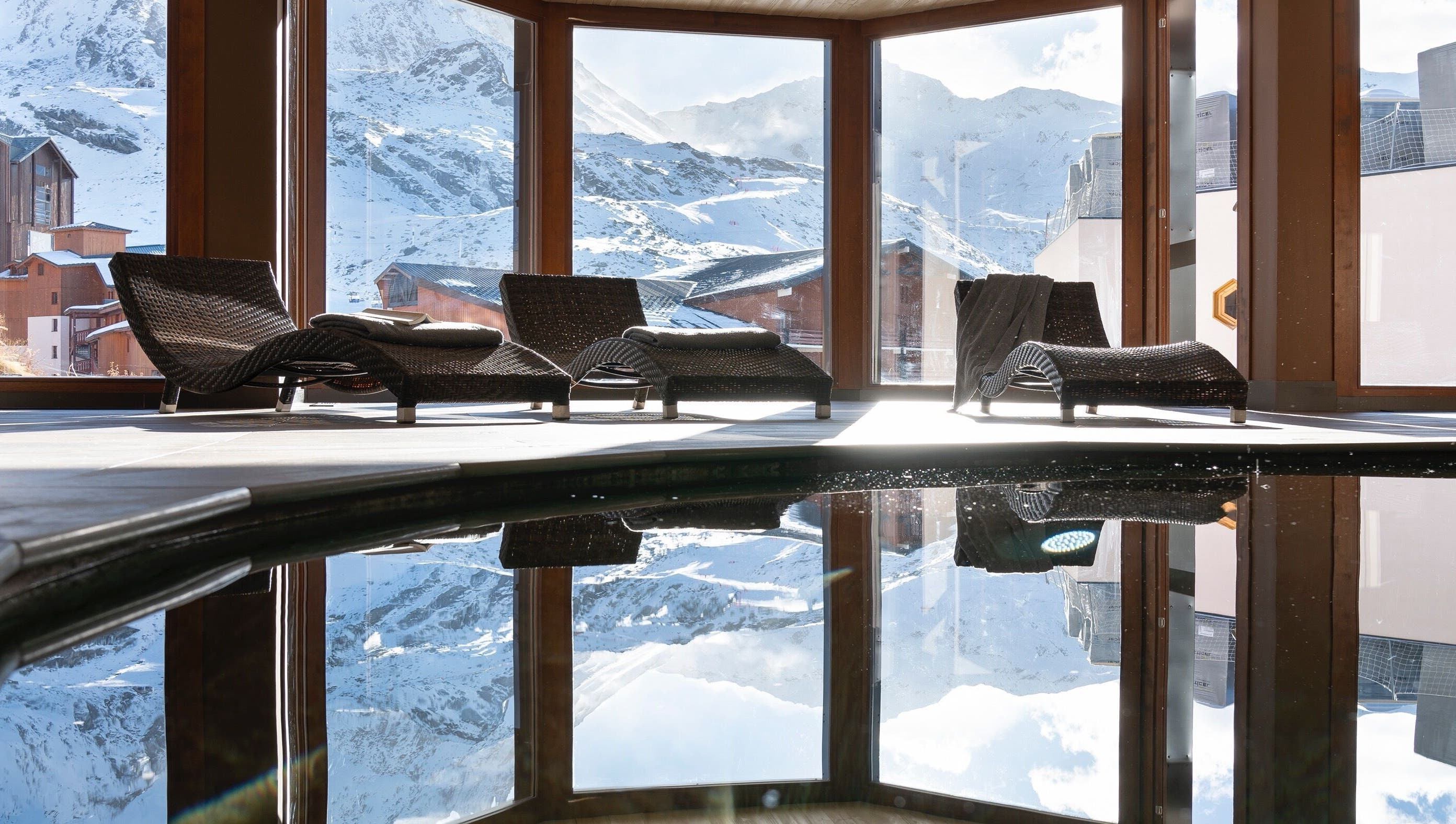 Intérieur lumineux de Spa Oxalys à Val Thorens, FR avec chaises longues et vue montagne.