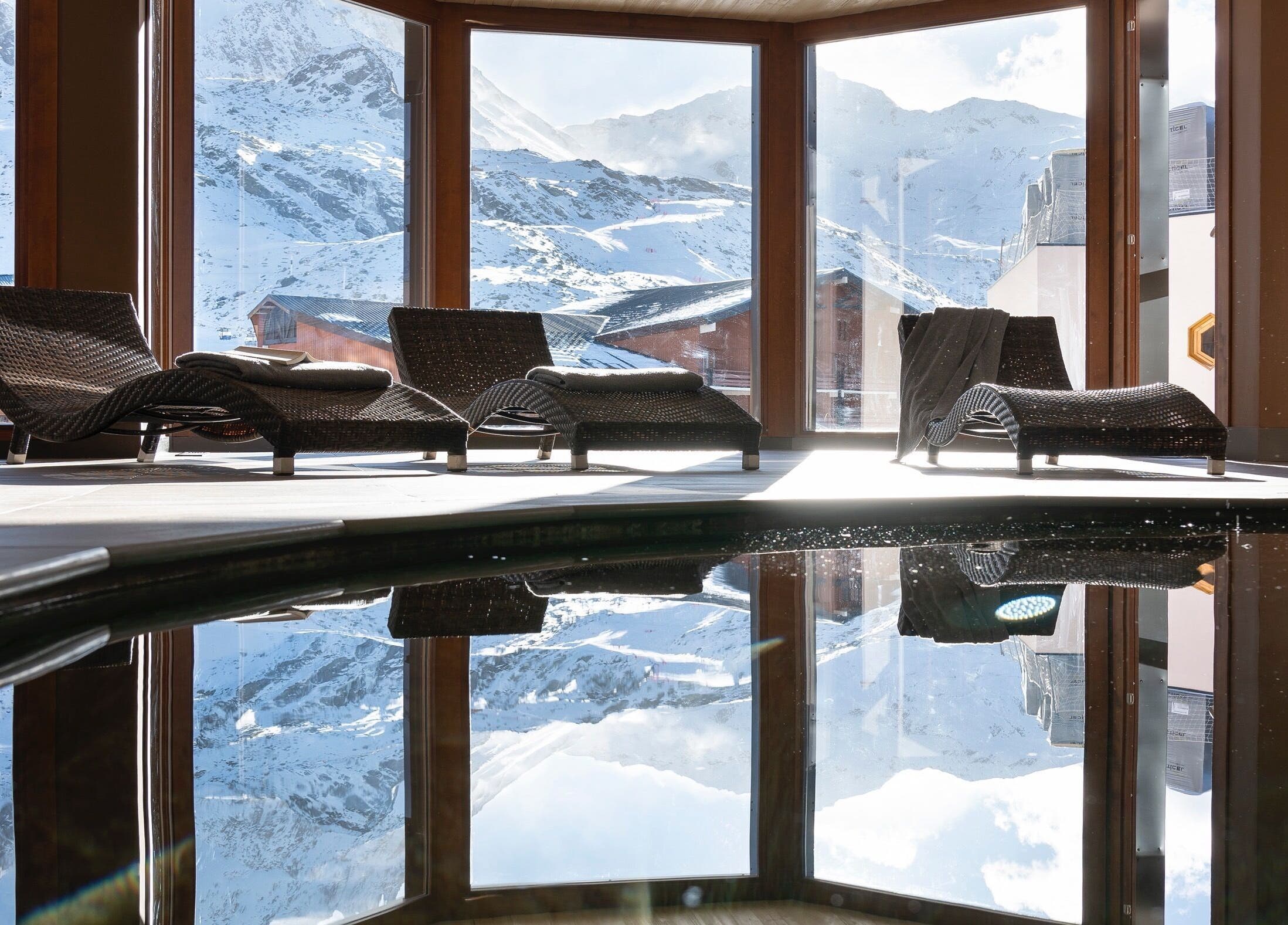 Intérieur lumineux de Spa Oxalys à Val Thorens, FR avec chaises longues et vue montagne.