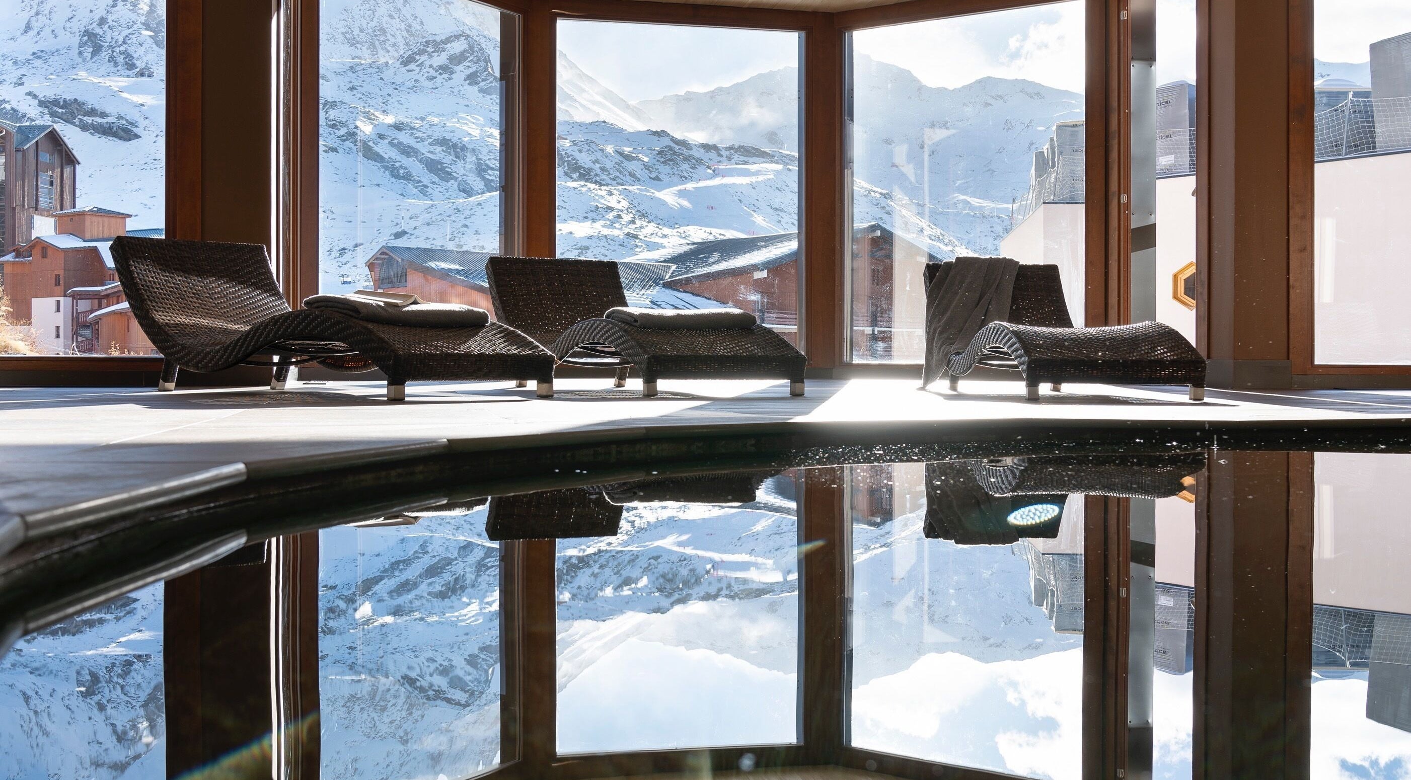 Intérieur lumineux de Spa Oxalys à Val Thorens, FR avec chaises longues et vue montagne.