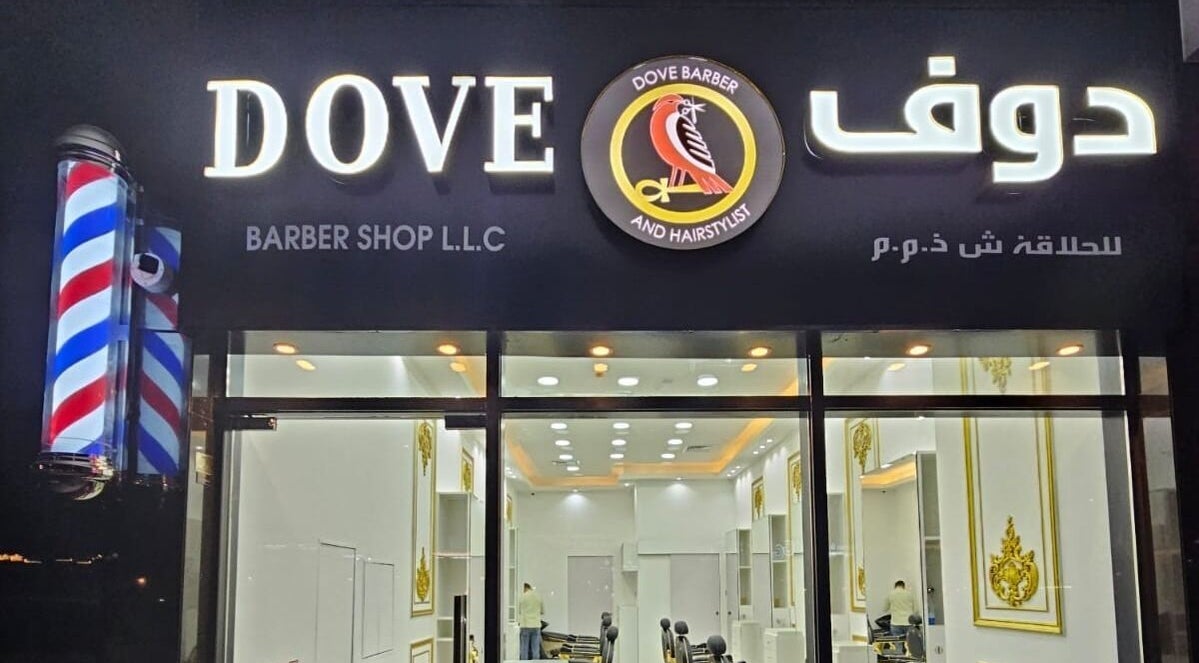 Front entrance of Dove Barbershop in Dubai, Dubai, AE, illuminated at night, showcasing modern design.