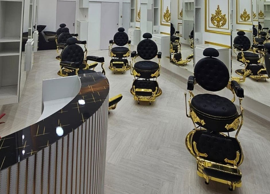 Luxurious black and gold barber chairs at Dove Barbershop, Dubai, Dubai, AE, reflecting opulence.