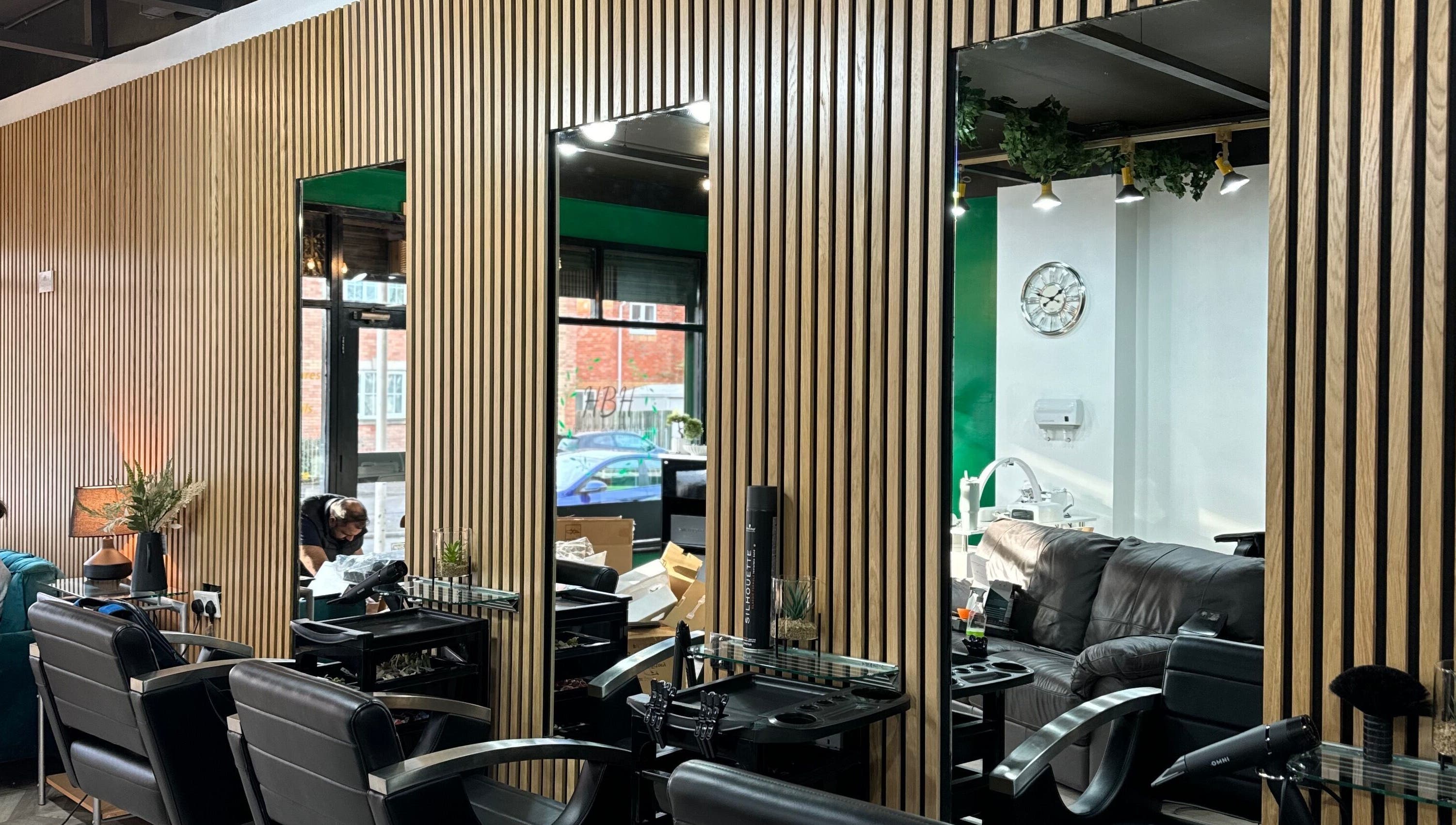 Modern salon interior at Hair and Beauty Hub, Kettering, England, GB with stylish chairs and wooden decor.