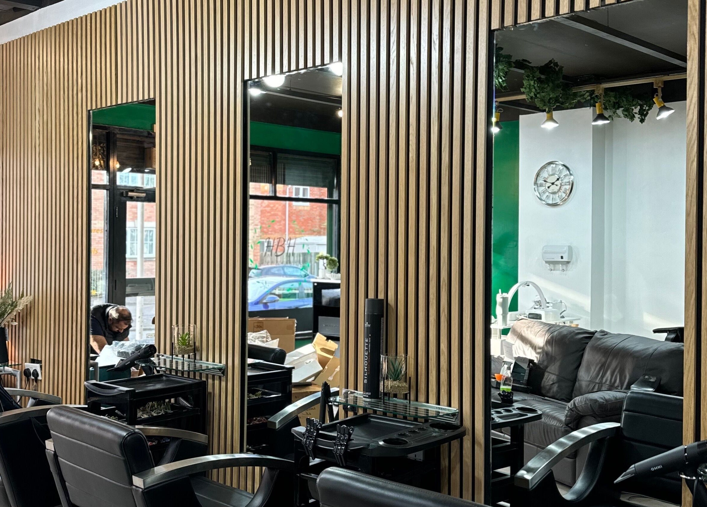 Modern salon interior at Hair and Beauty Hub, Kettering, England, GB with stylish chairs and wooden decor.