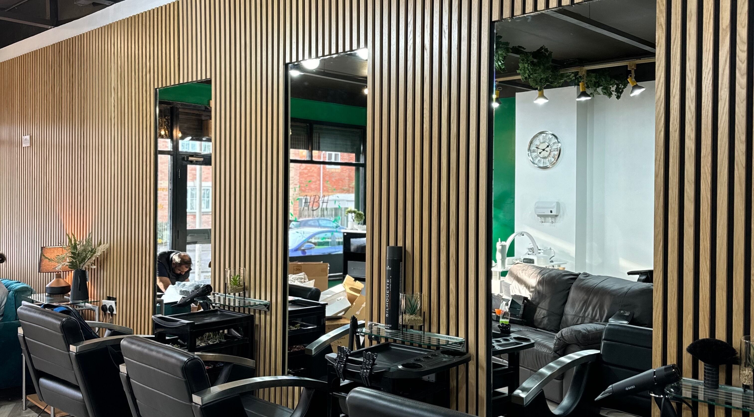 Modern salon interior at Hair and Beauty Hub, Kettering, England, GB with stylish chairs and wooden decor.