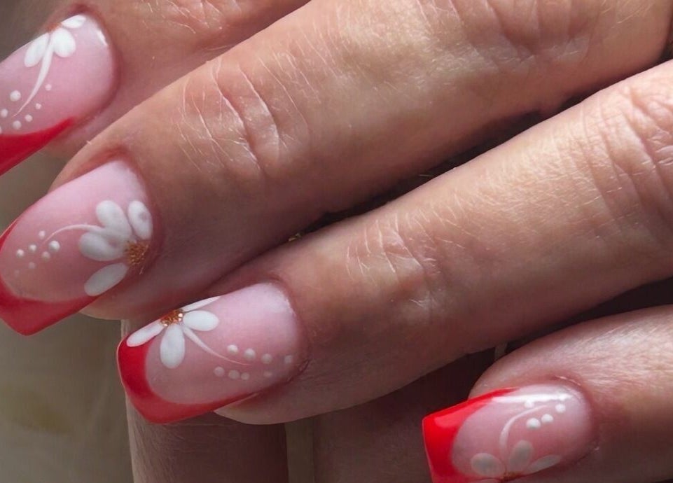 Diseño de uñas con flores rojas y blancas en Mari Nails Ribadeo, Ribadeo, ES.