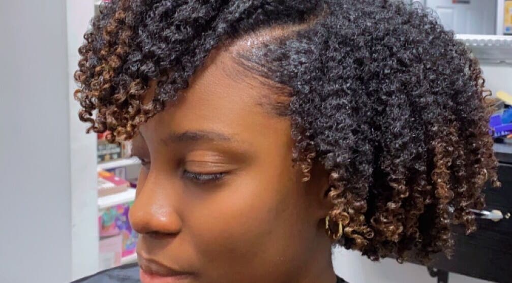Stylish curly hairstyle at Melanin n’ Coils, Grand Bahama, BS. Perfect blend of texture and flair.