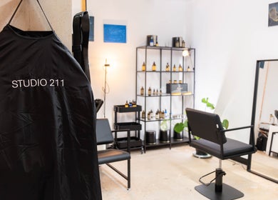 Chic interior of Studio 211 - Hair in London, England, GB, showing a salon chair and products.