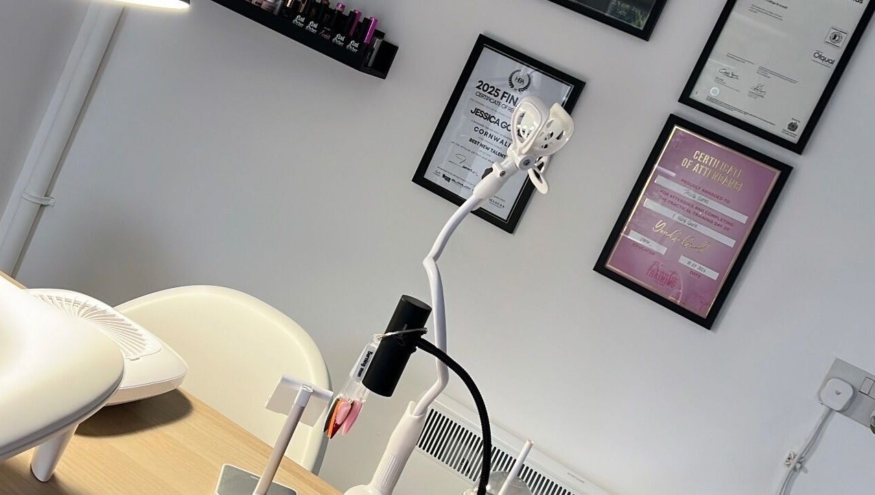 Detailed view of Nails By Jess salon in St Austell, England, highlighting certificates and modern workspace.