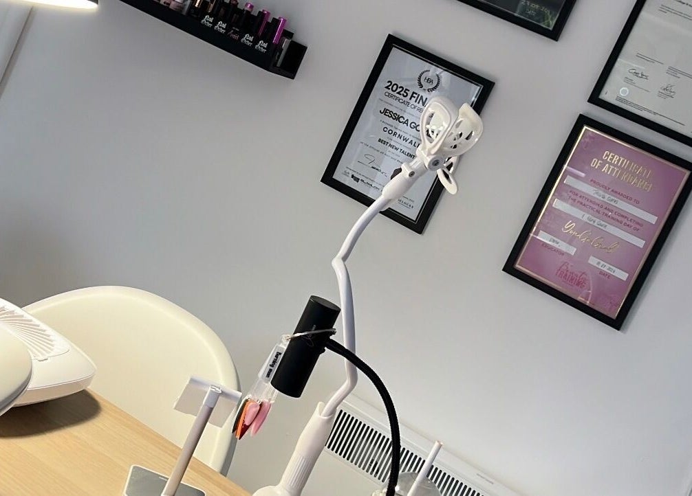 Detailed view of Nails By Jess salon in St Austell, England, highlighting certificates and modern workspace.