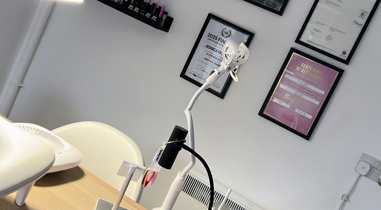 Detailed view of Nails By Jess salon in St Austell, England, highlighting certificates and modern workspace.