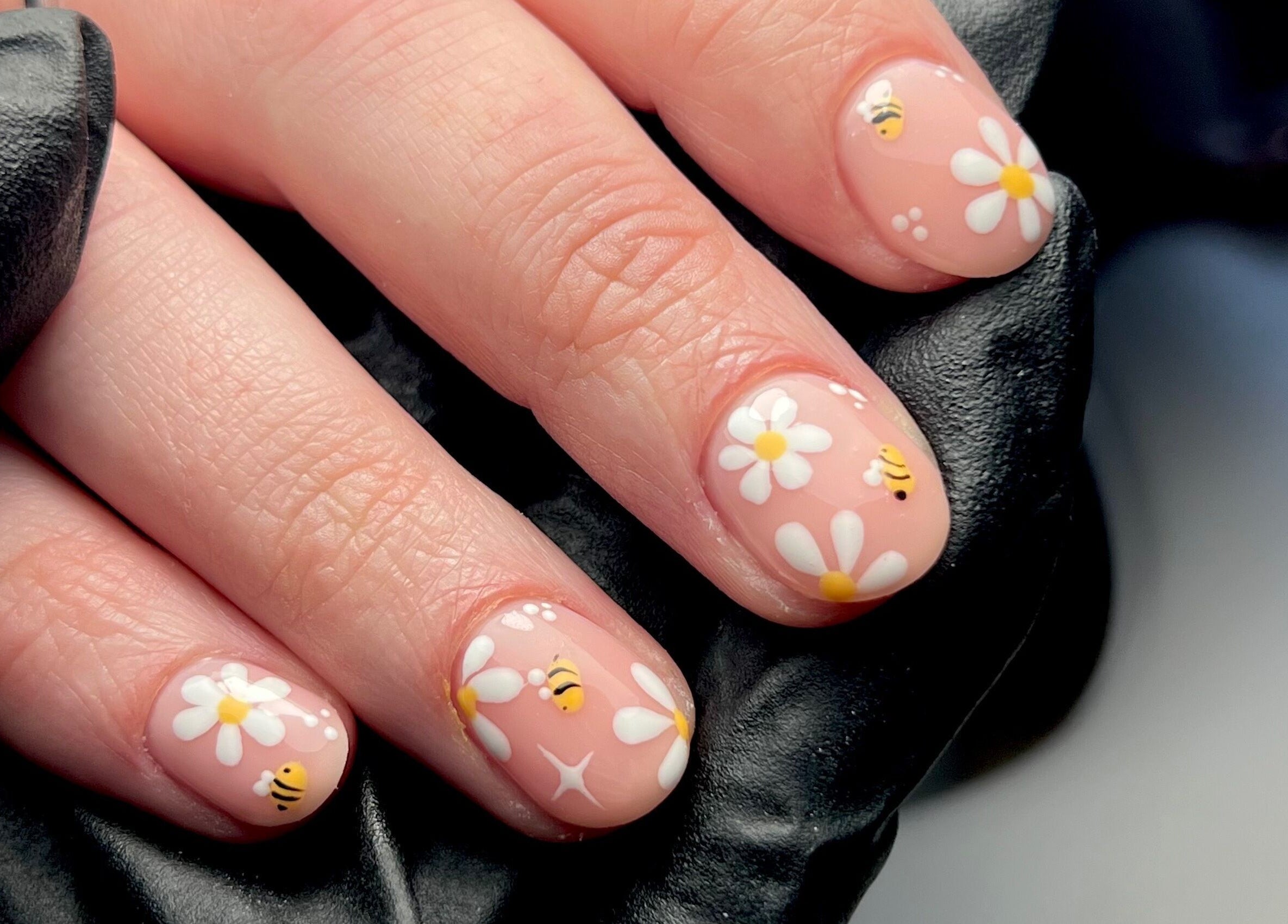 Close-up of bee and daisy nail art at Nails By Jess, St Austell, England, GB.