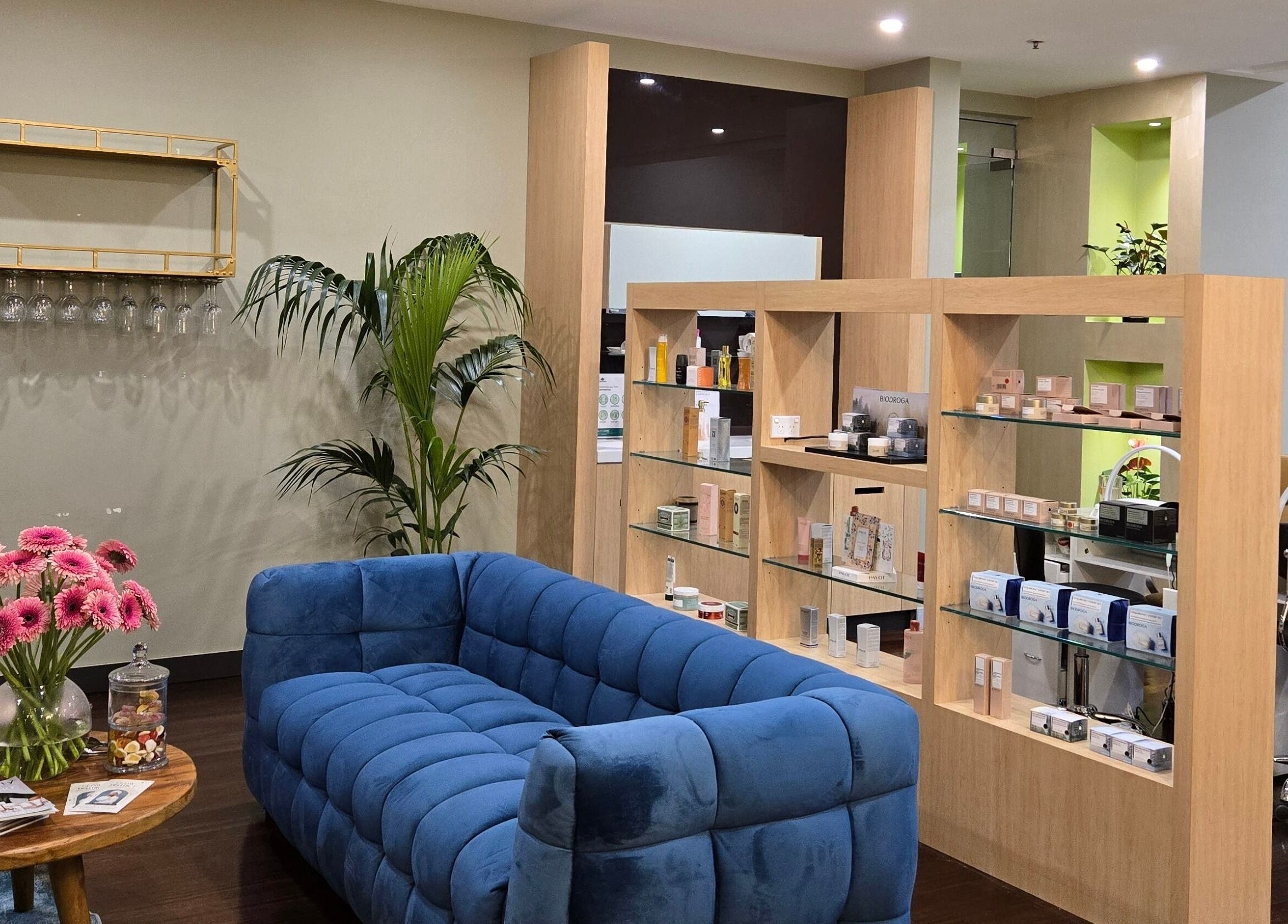 Stylish lounge at Glow District Beauty with blue sofa, floral decor, in Sydney, New South Wales, AU.