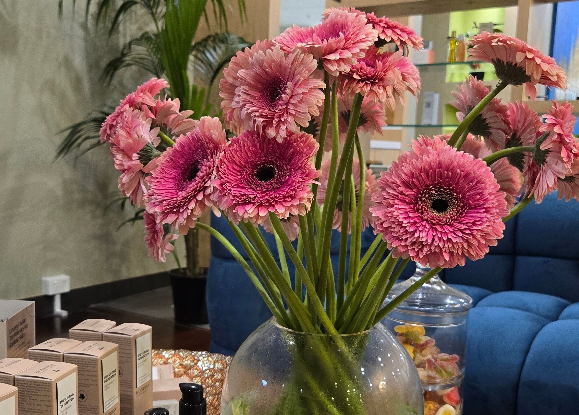 Vibrant pink flowers in a vase at Glow District Beauty, Sydney, New South Wales, AU, creating a serene atmosphere.