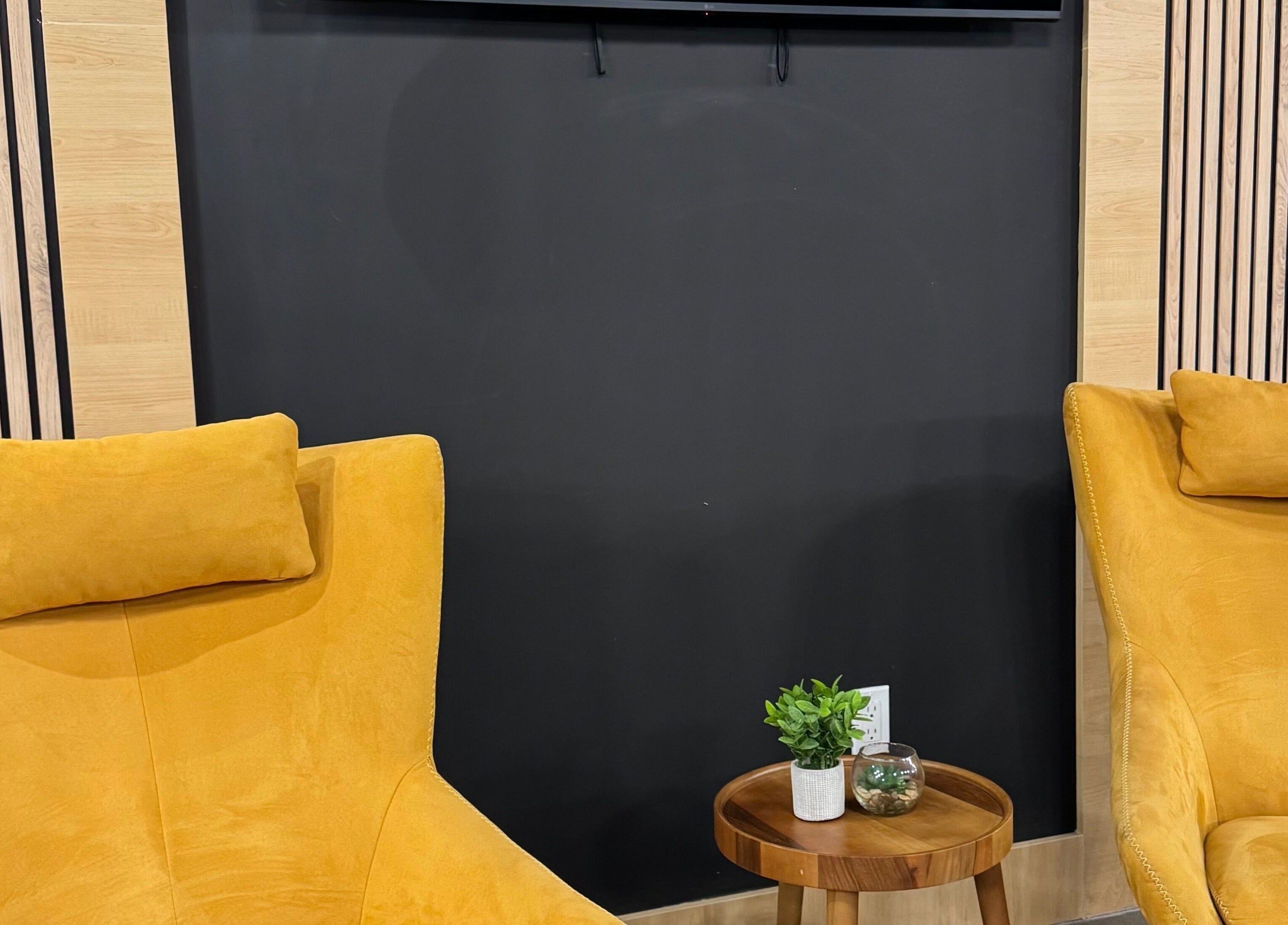 Bright yellow chairs with a wooden table at LV Aestheticca in Toronto, Ontario, CA, creating a cozy nook.