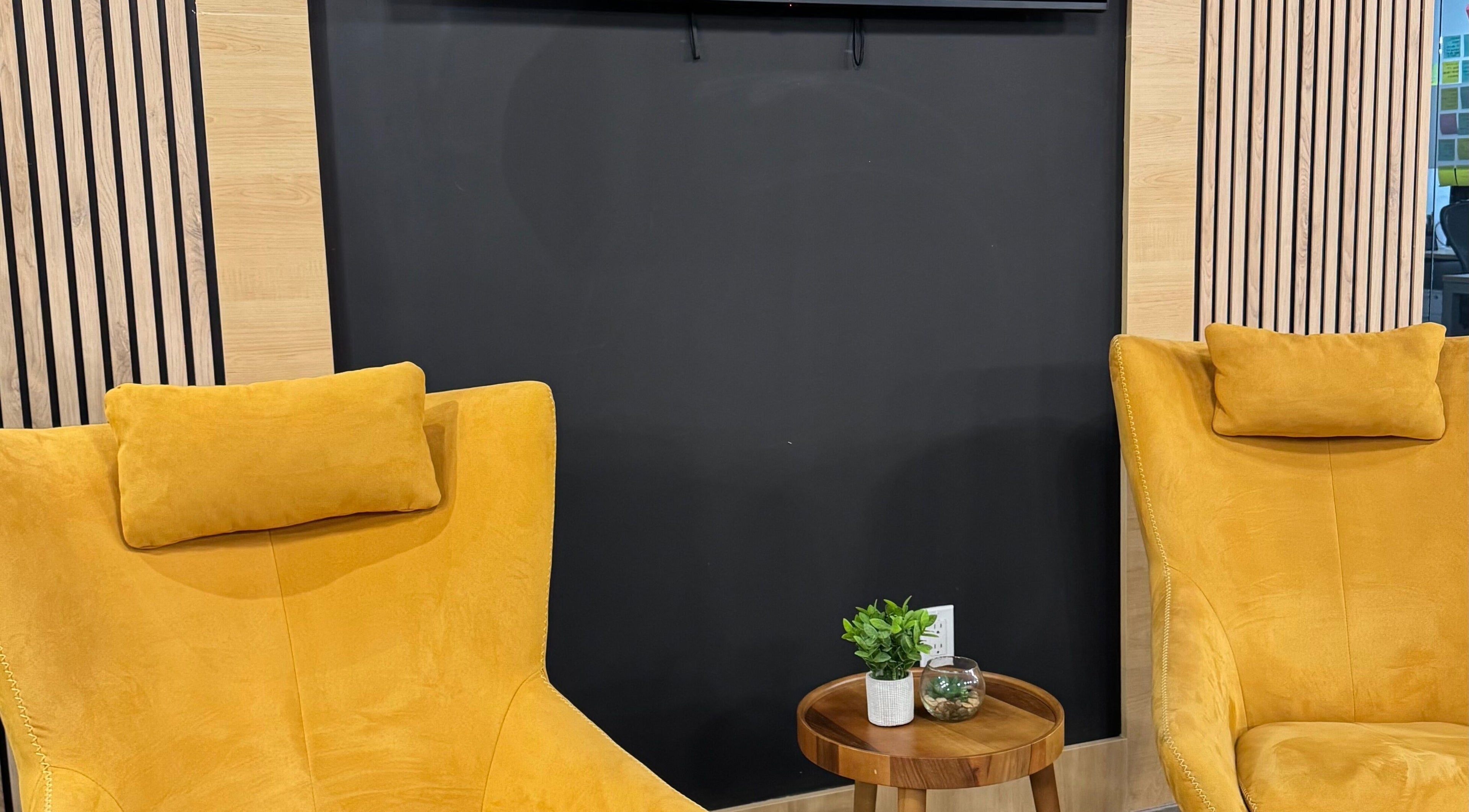 Bright yellow chairs with a wooden table at LV Aestheticca in Toronto, Ontario, CA, creating a cozy nook.