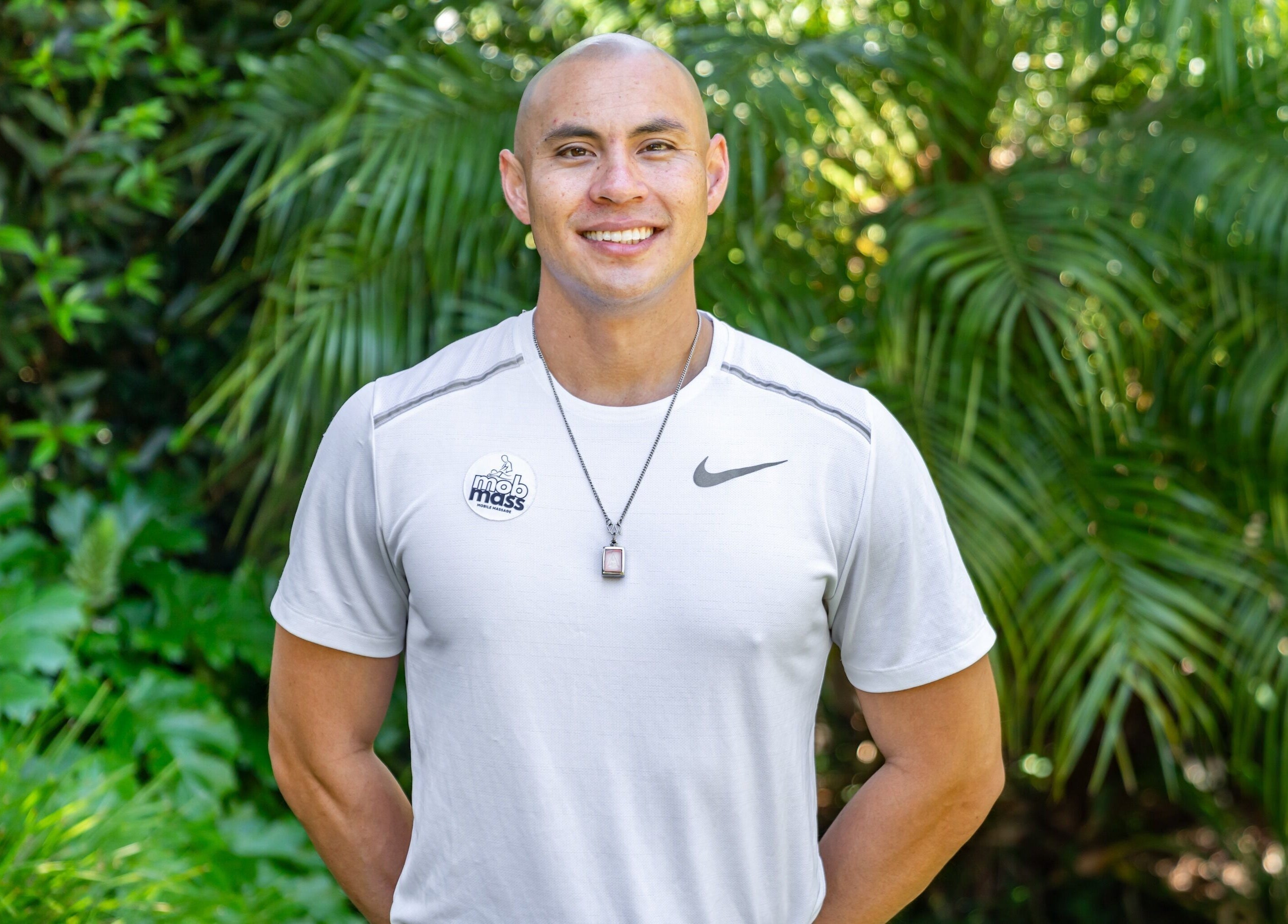 Therapist at Mob Mass- Mobile Massage Therapy in Auckland, NZ, amidst lush greenery.