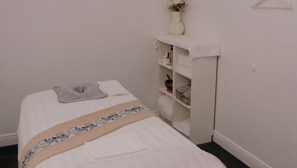 Serene massage room at Eden Spa Massage and Facial, Pembroke Pines, Florida, US, with a tidy bed and calming decor.