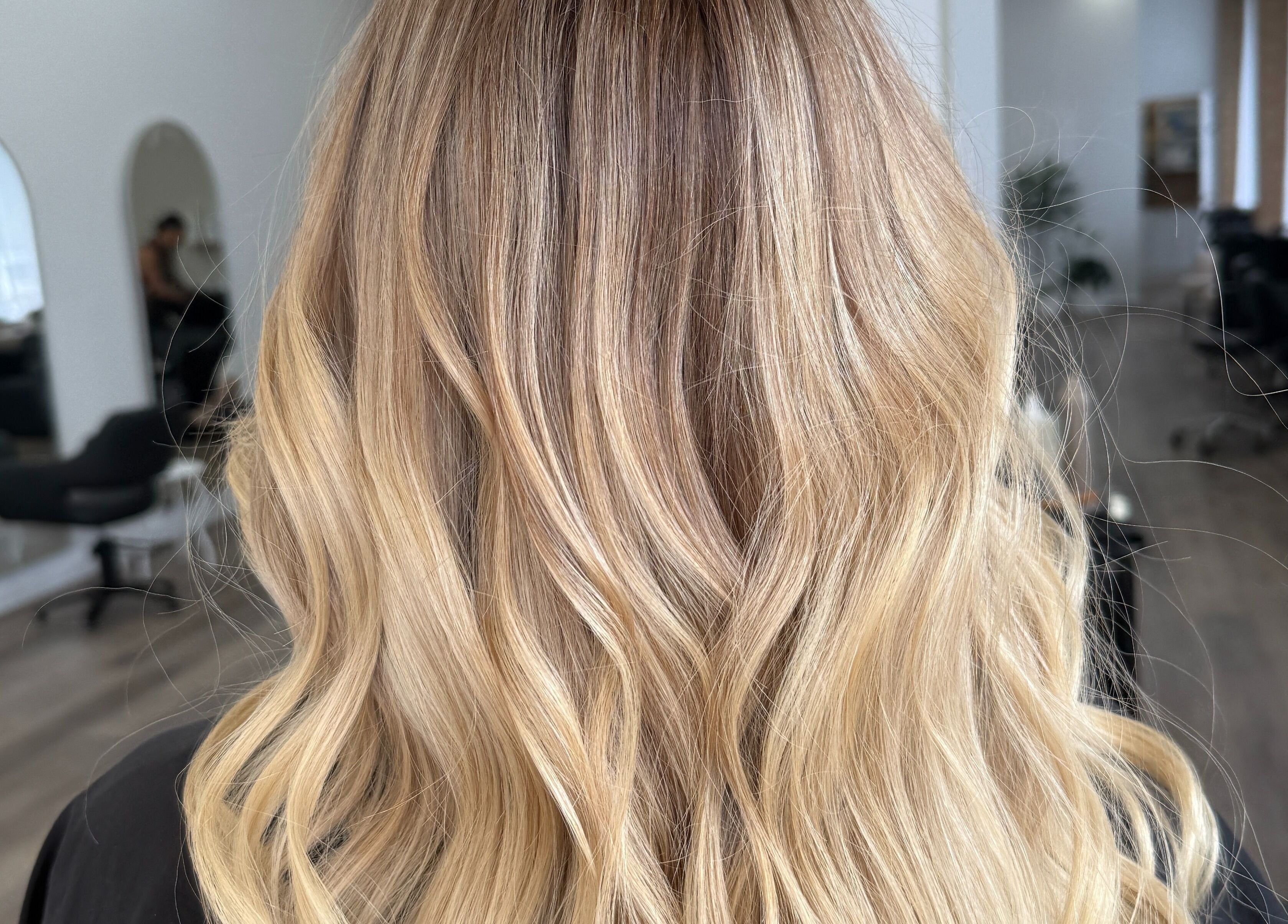 Elegant blonde waves styled at Hair By Jenna Lutgens in Melbourne, Victoria, AU featuring soft, flowing curls.