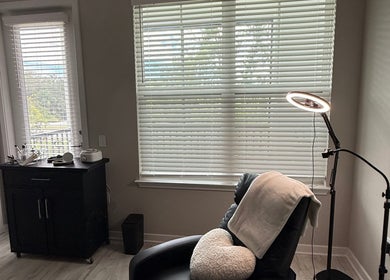 Relaxing treatment room at XBrows with reclining chair and soft lighting, located in Orlando, Florida, US.