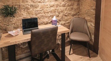 Elegant therapy room at The Pumphouse- Glendon Lodge Farm Kettering, England, GB, featuring a wooden desk and chairs.