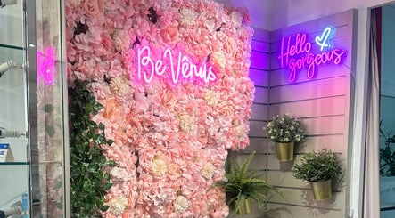 Rosa Blumenwand mit leuchtendem Logo von BE Vênus - Esthetic Salon KLG, Thun, Bern, CH.