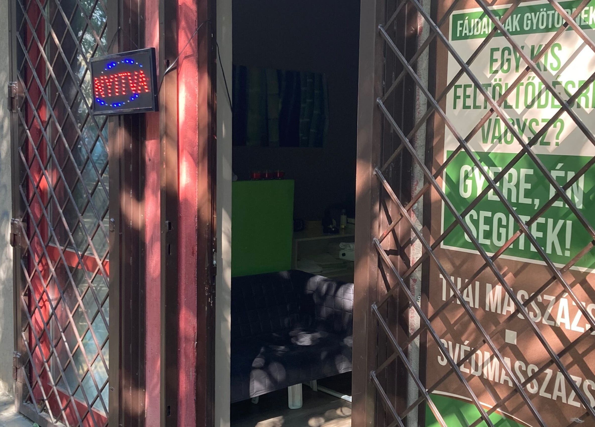 Ágnes Masszázs bejárata Budapesten, árnyékos kültéri tábla és nyitva jelzés.