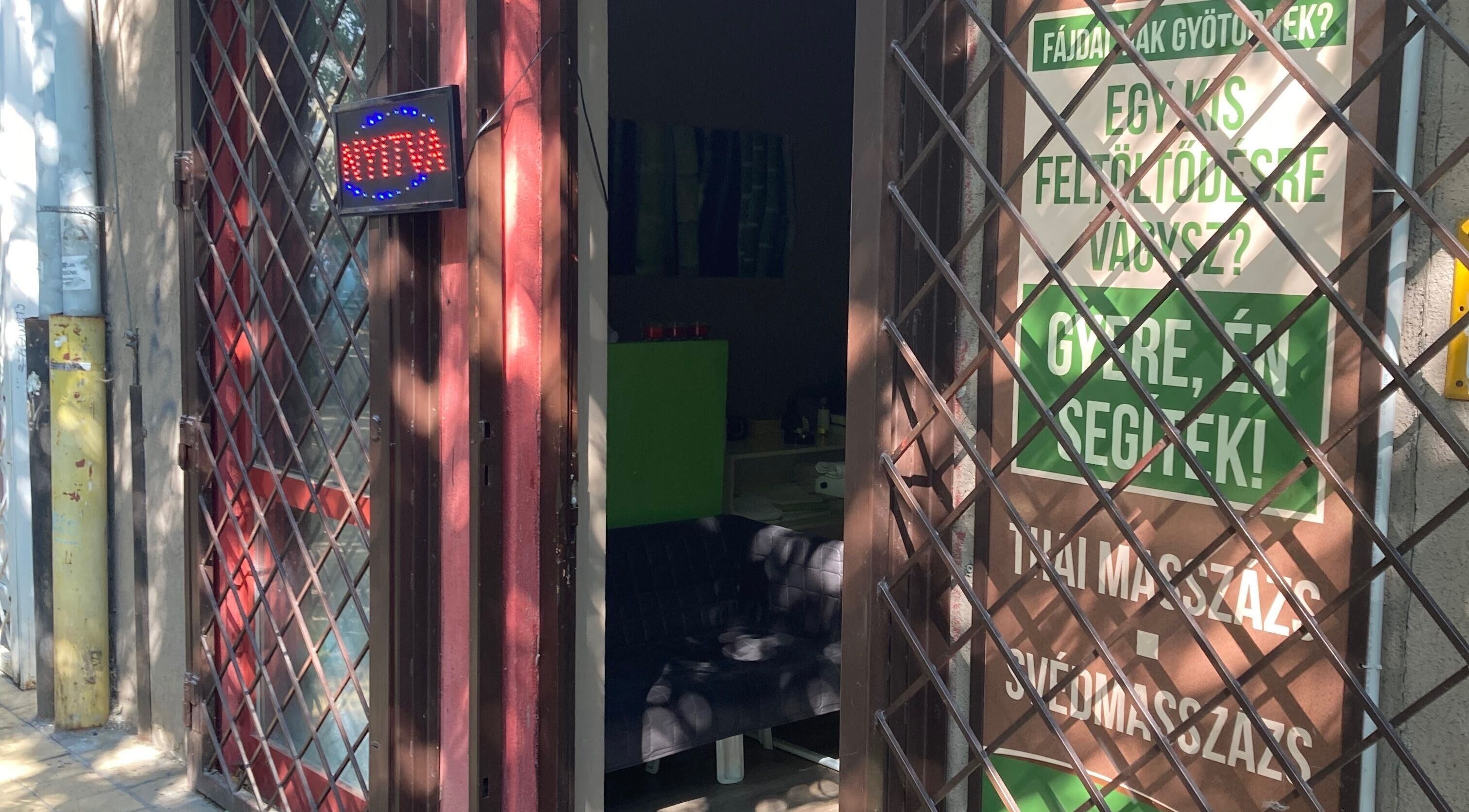 Ágnes Masszázs bejárata Budapesten, árnyékos kültéri tábla és nyitva jelzés.