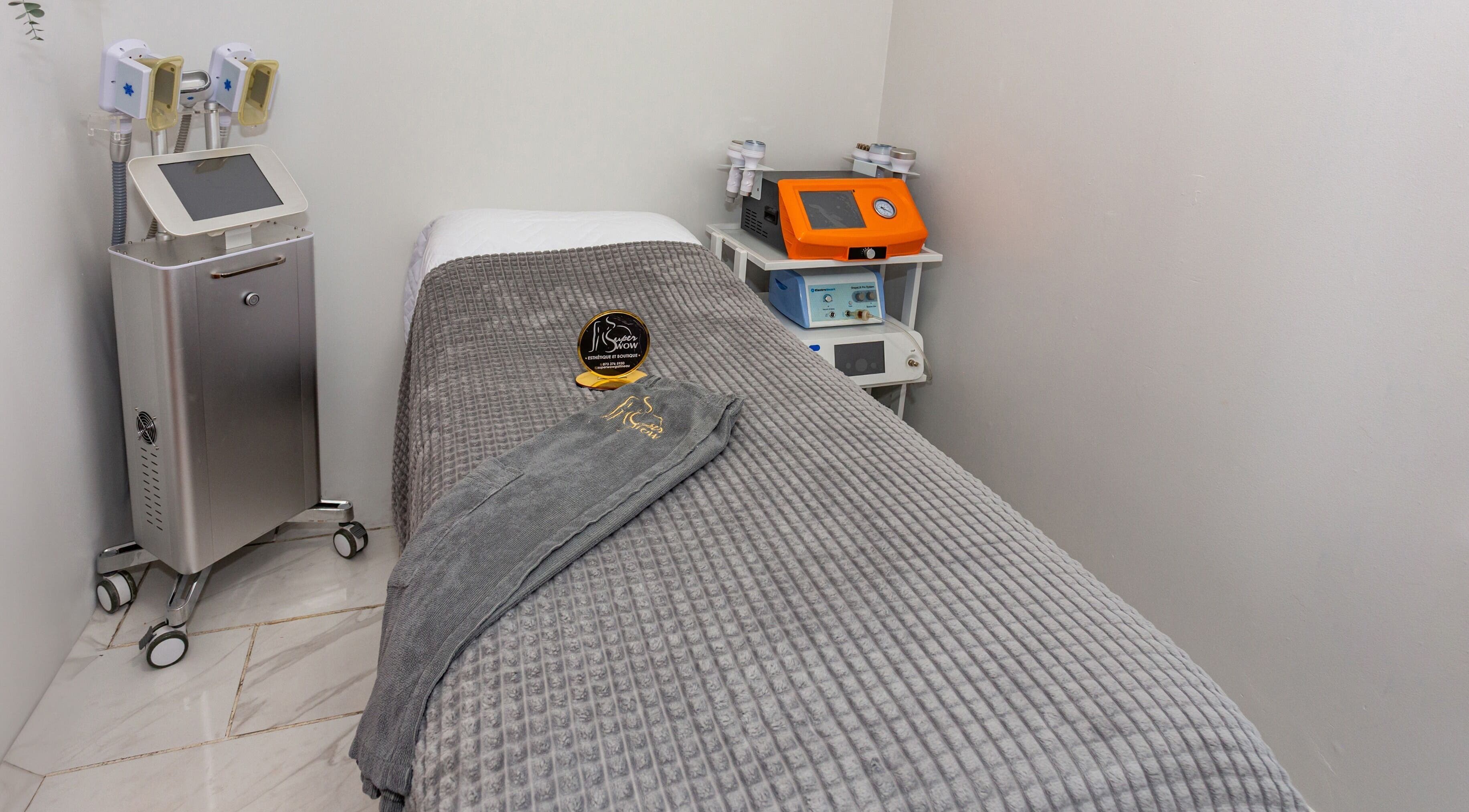 Salle de soins moderne au Super Wow Studio à Gatineau, Québec, CA, avec table de massage et équipements spécialisés.