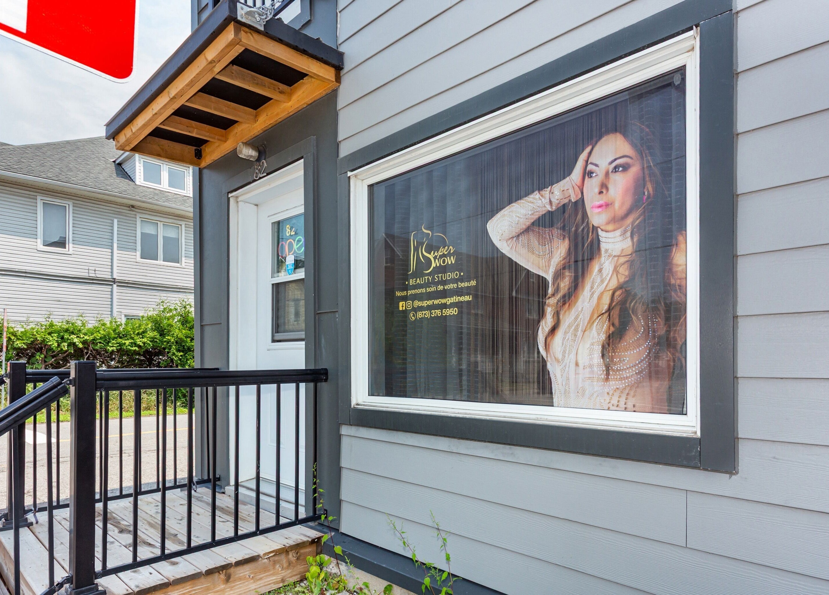 Entrée de Super Wow Studio à Gatineau, Québec, CA avec une affiche élégante en vitrine.