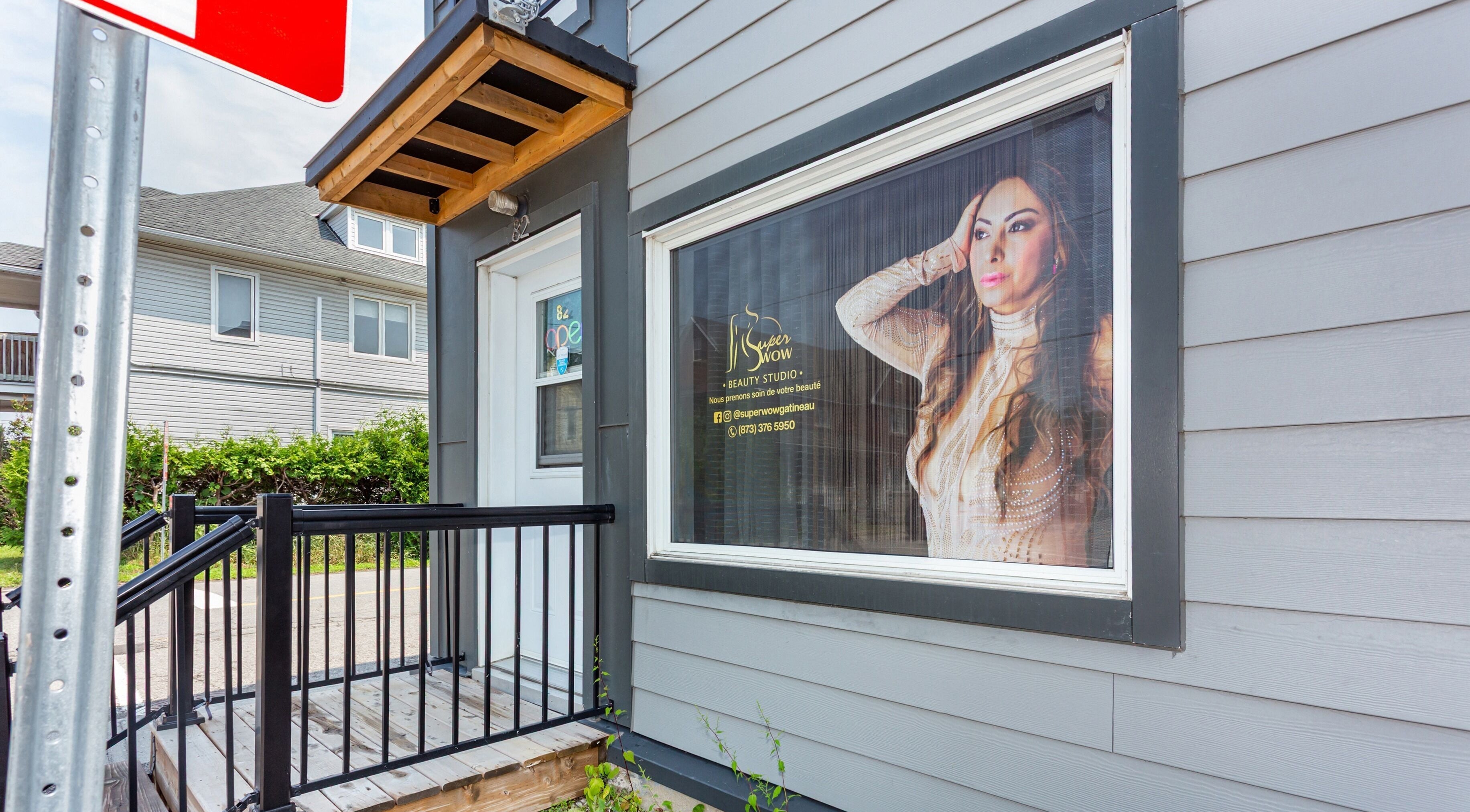 Entrée de Super Wow Studio à Gatineau, Québec, CA avec une affiche élégante en vitrine.