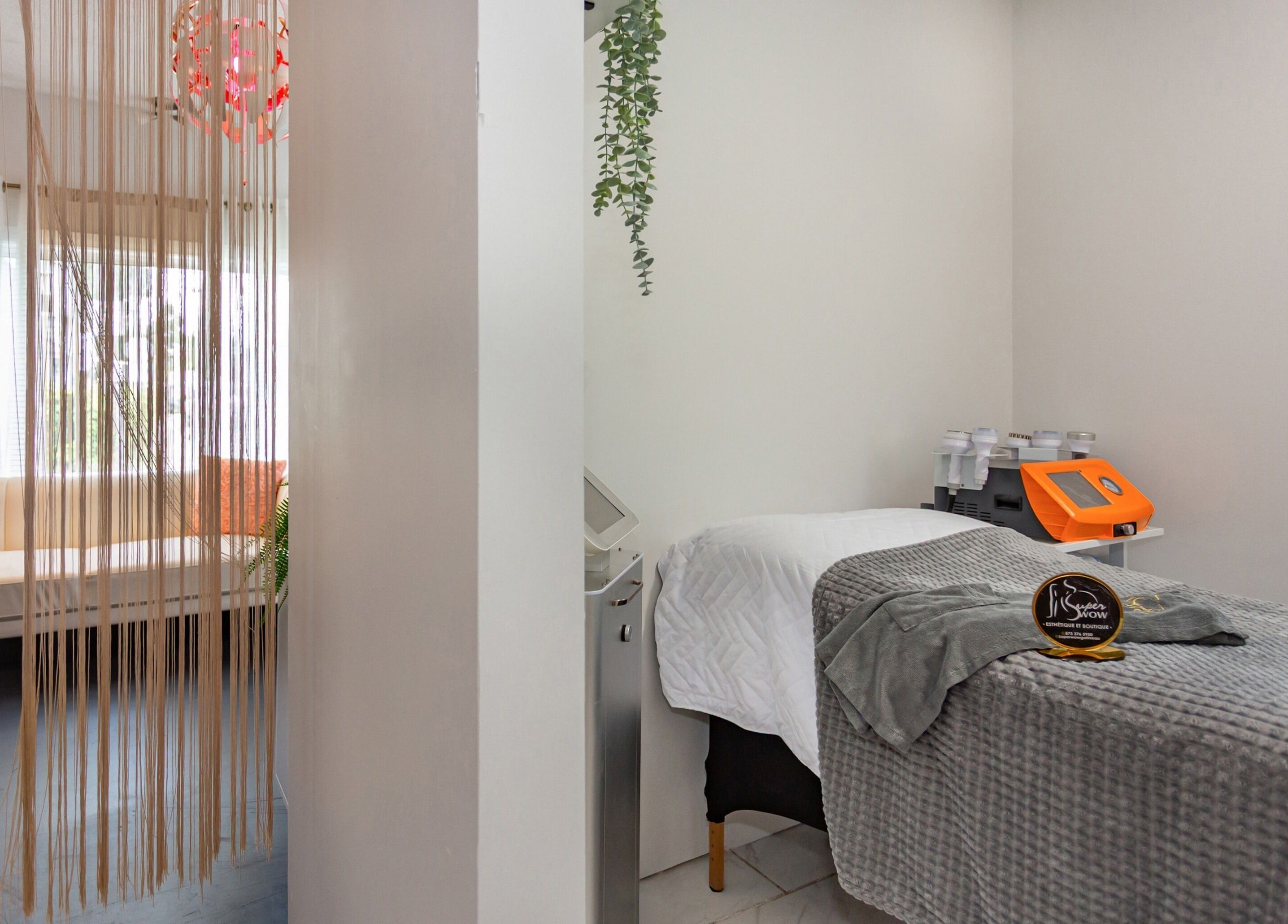 Salle de soin paisible à Super Wow Studio, Gatineau, Québec, CA, avec lit de massage et décoration élégante.