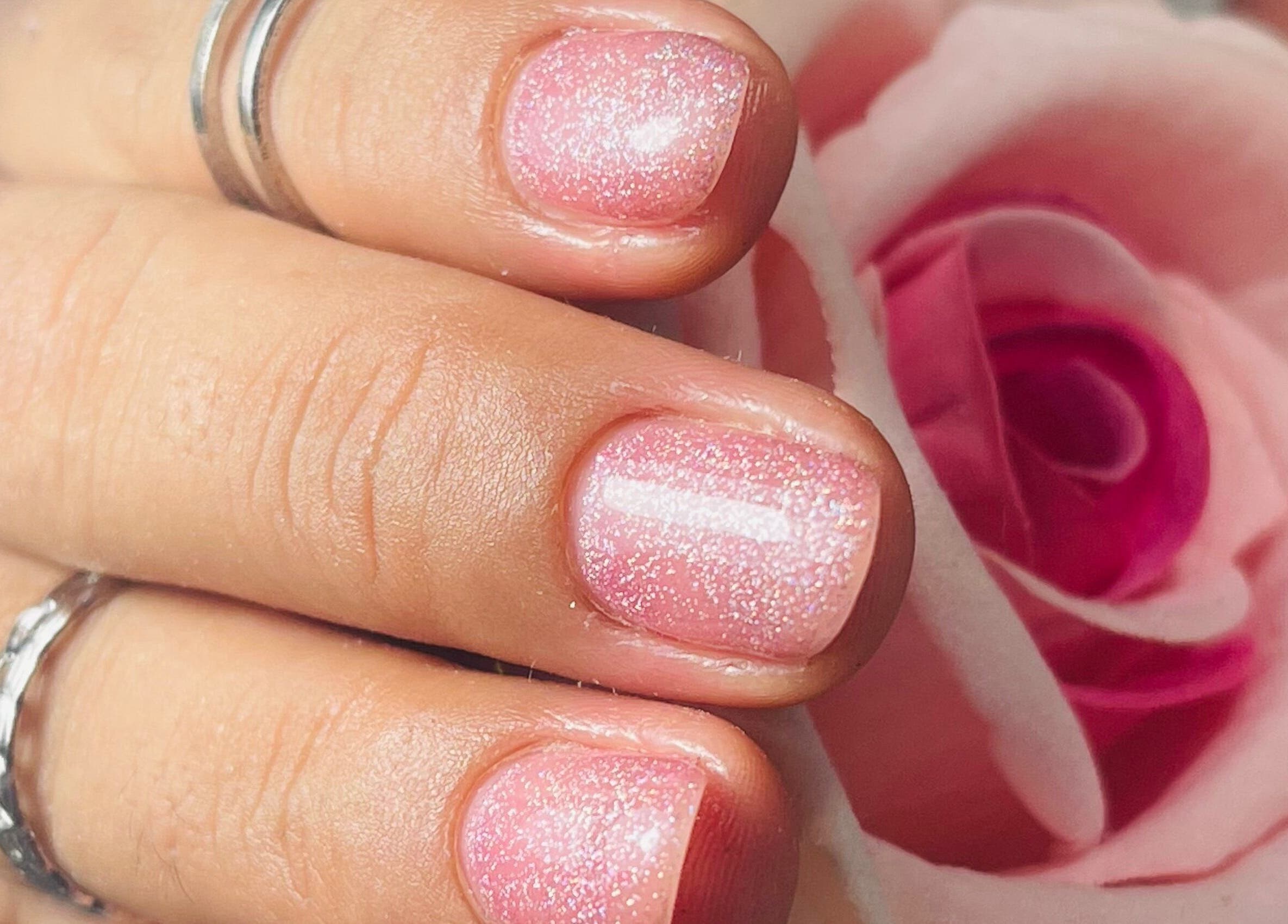 Manicure rosa brillante en I Love Nails by Laura, Mérida, Yucatán, MX, acentuada por una rosa.
