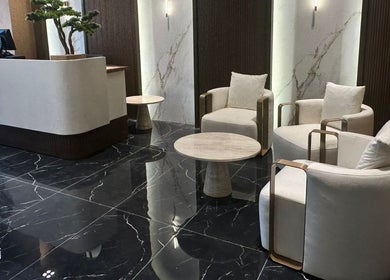 Modern lounge area at Generation Gentleman Barbershop, دبي, دبي, AE, with sleek black marble and cozy chairs.