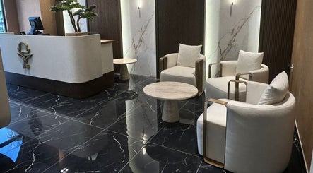 Modern lounge area at Generation Gentleman Barbershop, دبي, دبي, AE, with sleek black marble and cozy chairs.