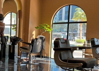 Interior of Generation Gentleman Barbershop in دبي, دبي, AE, featuring stylish barber chairs by tall windows.