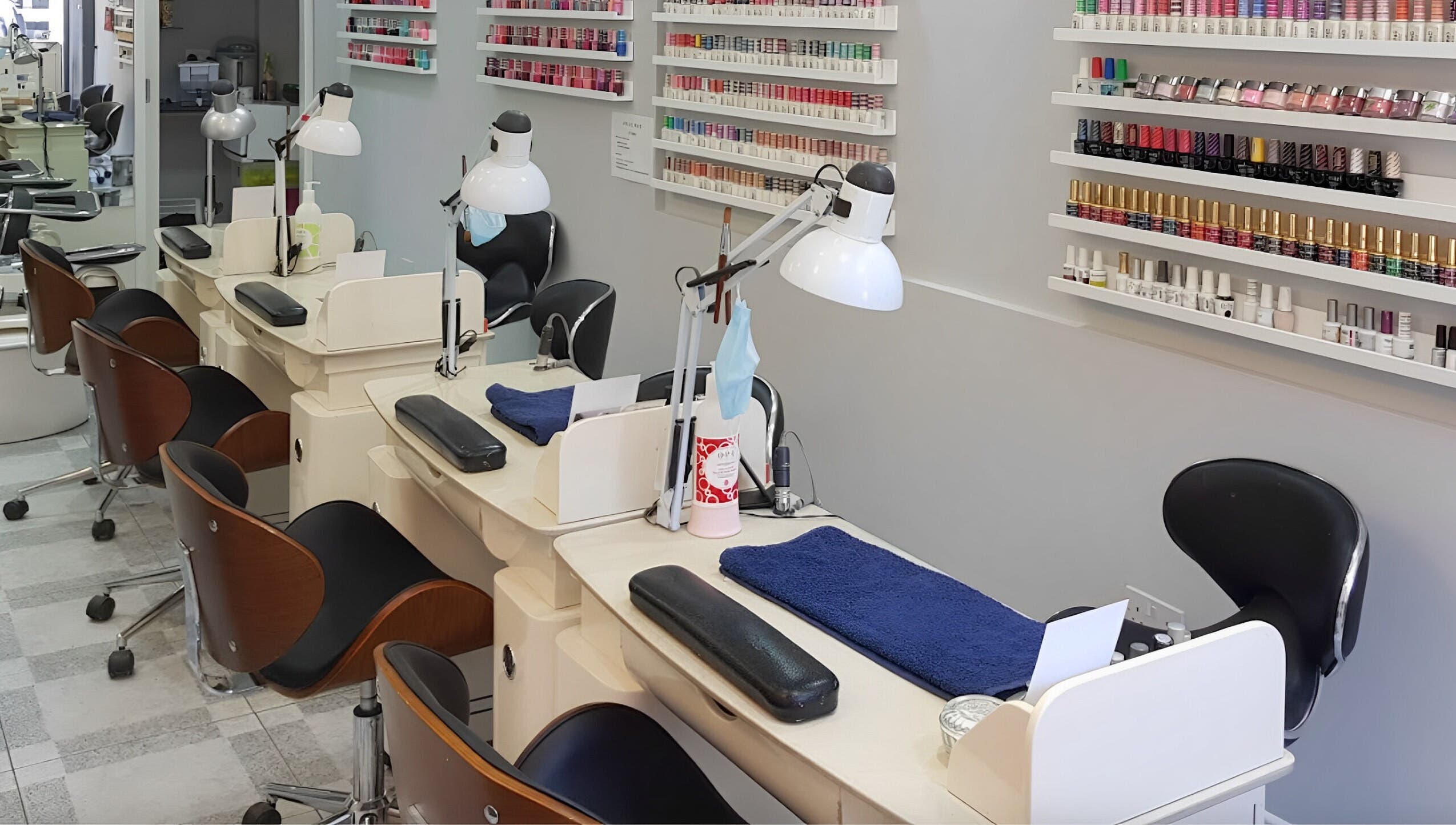 Nail stations at Coco's Nails in Basingstoke, England, GB with various polish options on display.