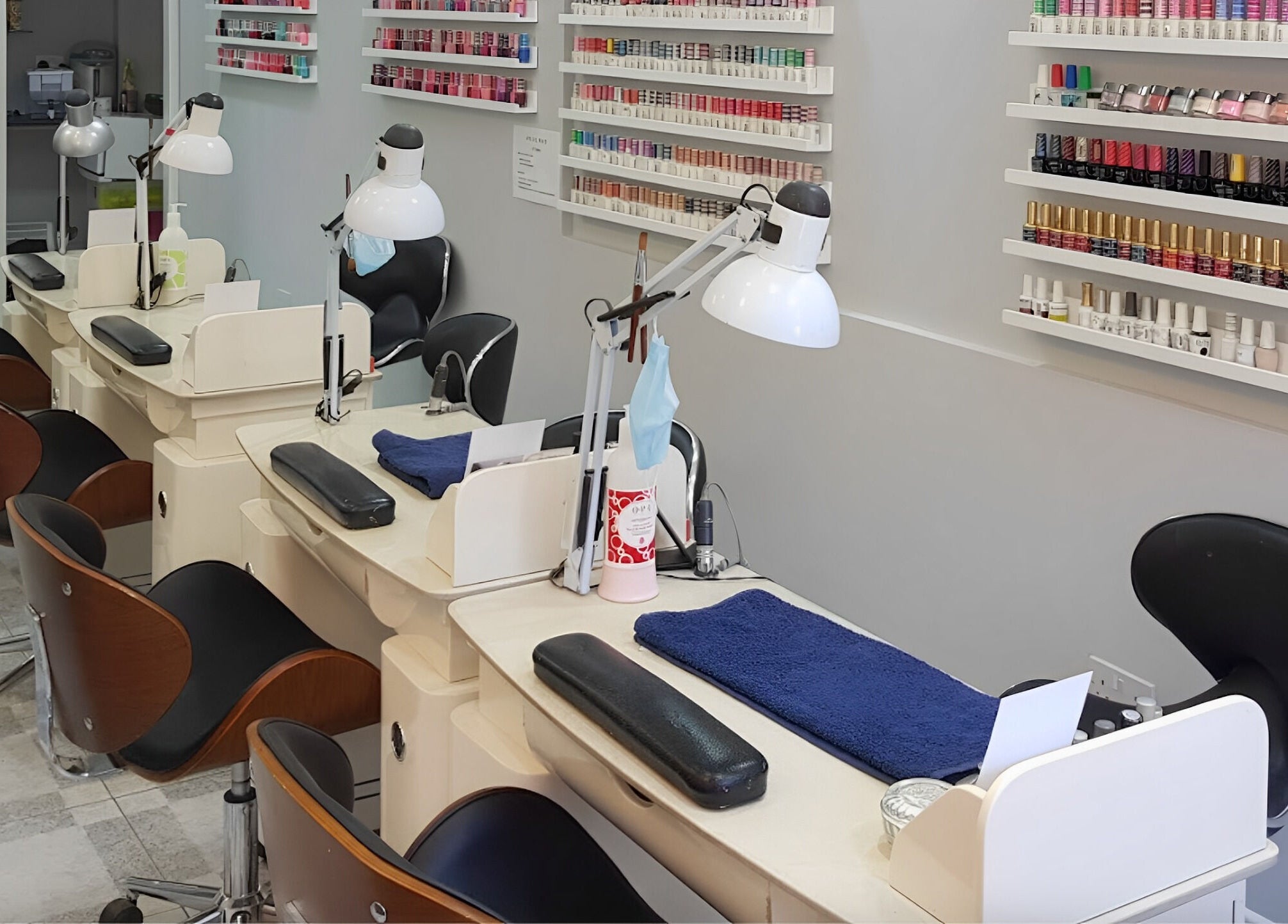 Nail stations at Coco's Nails in Basingstoke, England, GB with various polish options on display.