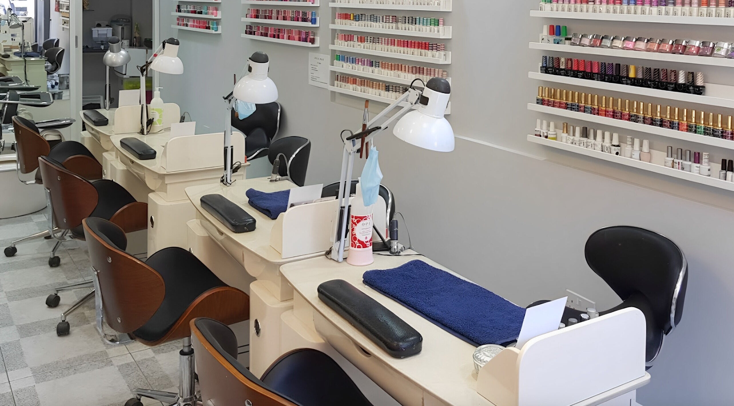 Nail stations at Coco's Nails in Basingstoke, England, GB with various polish options on display.