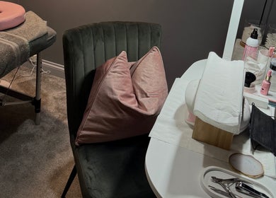 Cozy treatment area at Beauty By Caitlin, Chalford, England, GB with a plush chair and preparation table.