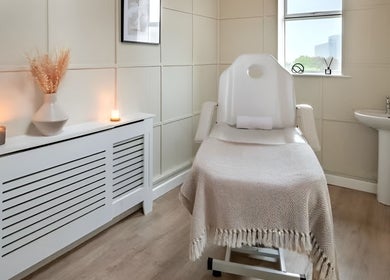 Relaxing treatment room at CC Cosmetics, Exeter, England, GB, featuring a massage chair and soft lighting.