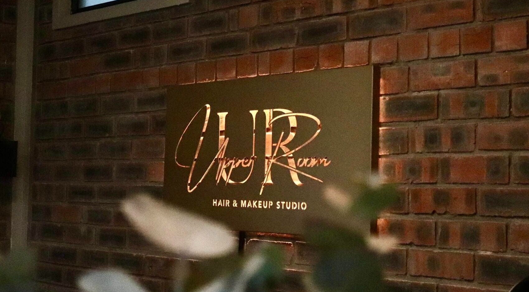 Upper Room Hair & Makeup Studio sign against brick wall in George, Western Cape, ZA.