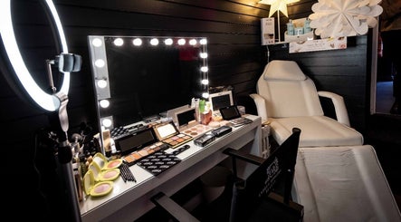 Makeup station at Andrea Rodgers Beauty, Cushendall, Northern Ireland, GB with illuminated mirror and beauty products.